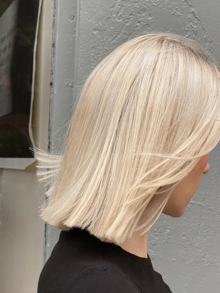 Platinum blonde blunt bob, seen from the side, in the salon